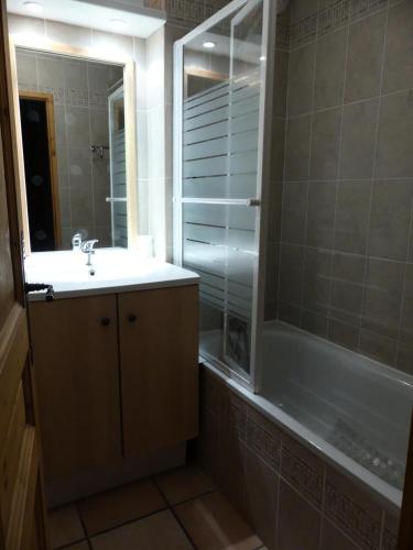 une salle de bain avec un lavabo, une baignoire et un miroir dans l'établissement Ancolie Chalets De La Vallee D'or - 3 pièces 6 personnes exposé ouest MAE-7884, à Valloire