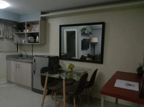 a kitchen with a glass table and a dining room at Elegant 2BR Hampton Suites with Pool & WiFi in Anabu Primero