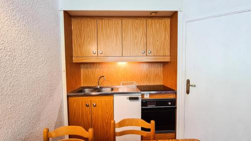 une petite cuisine avec un évier et une cuisinière dans l'établissement Résidence Andromede - Studio pour 4 Personnes 12, à Flaine