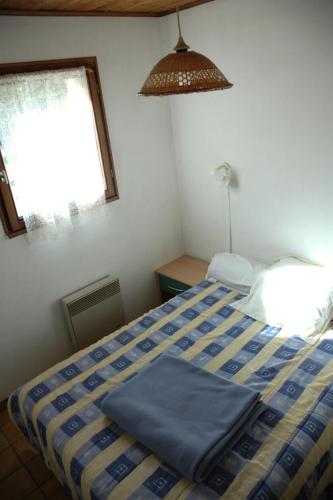 une chambre avec un lit avec des draps bleus et une fenêtre dans l'établissement Résidence Les Alpages - 3 pièces 6 personnes exposé Sud MAE-8054, à Valloire