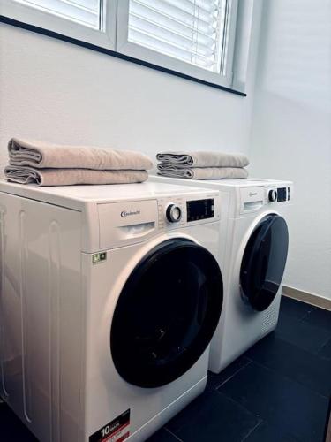 a washing machine with towels on top of it at Lakefront View Entire Apartment with 2 bedrooms, 2 full bathrooms & Balcony Waterview in Reichenau