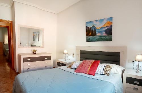 um quarto com uma cama e um quadro na parede em Sol, mar y arena em Torrevieja