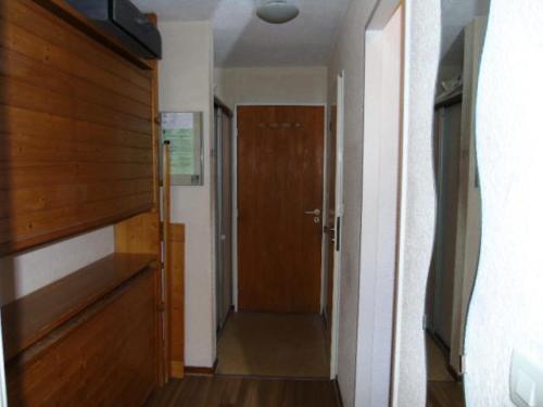 - un couloir avec une porte en bois dans l'établissement Résidence Thabor - Studio pour 3 Personnes MAE-8894, à Modane