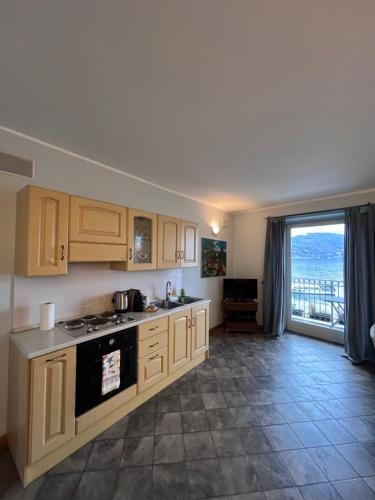 a kitchen with wooden cabinets and a view of the ocean at Appartamento il Porto in Baveno