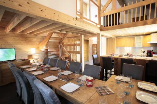 une salle à manger avec une grande table et des chaises en bois dans l'établissement Les Chalets Du Grand Galibier - 4 pièces duplex 8 personnes exposé Sud MAE-8094, à Valloire