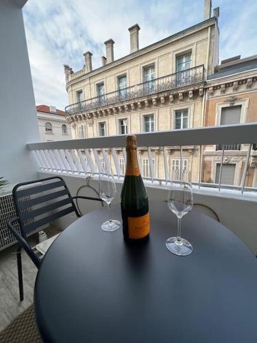 une bouteille de vin posée sur une table avec deux verres dans l'établissement Superbe Studio avec balcon Rue d’Antibes, à Cannes