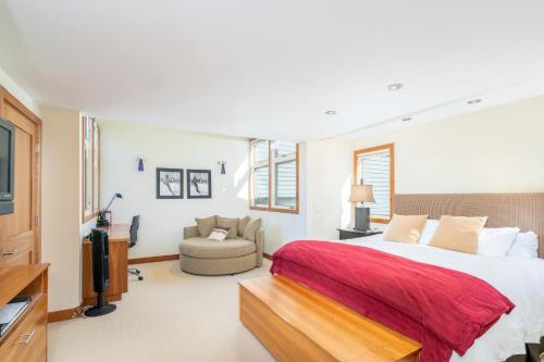 a bedroom with a large bed and a chair at Spacious 3 bedroom Condo Easy walk to Grocery Store and Chairlift 7 in Telluride
