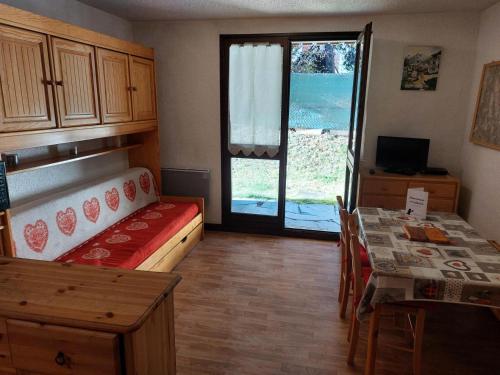 Cette petite chambre comprend un lit, une table et une fenêtre. dans l'établissement Résidence Les Cretes - Studio cabine 4 personnes 2 exposé Ouest MAE-8404, à Valloire