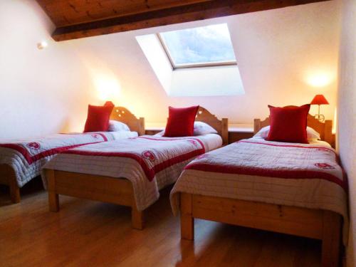 a bedroom with two beds with red pillows at Résidence Les Fermes Du Planet - Pièces 74 in Valloire