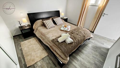 um quarto com uma cama grande e 2 almofadas em Magnólia House em Santa Cruz - Madeira