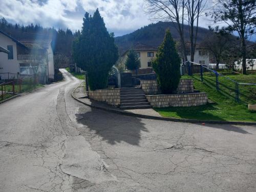 una calle vacía con árboles a un lado de la carretera en Apartman Sadba en Goražde