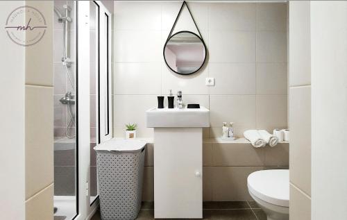 uma casa de banho branca com um lavatório e um espelho em Magnólia House em Santa Cruz - Madeira
