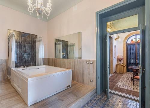 a large bathroom with a tub and a mirror at Villa Nicolaci - Liberty Suites in Noto