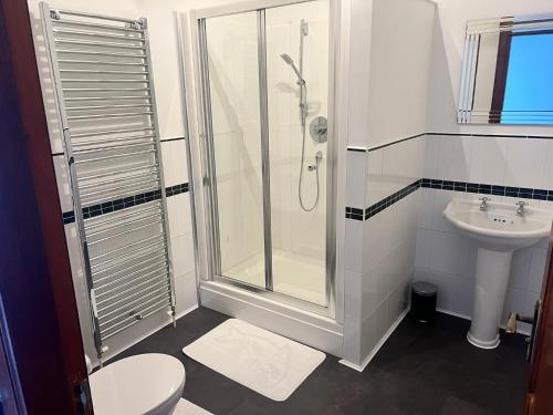 een badkamer met een douche, een toilet en een wastafel bij Coylebrae House in Ayr