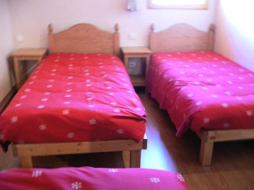 Cette chambre comprend 2 lits avec des draps rouges. dans l'établissement Chalet Les Aiguilles - Duplex 5 pièces 10 personnes exposé Nord-Est 3 MAE-8734, à Valloire