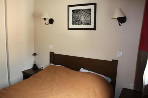 a bedroom with a bed and two lights on the wall at Les Chalets Valoria - 3 Pièces pour 6 Personnes 24 in Valloire