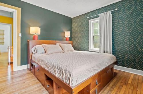 a bedroom with a bed and a green wall at The Peacock House - Close to Restaurants and Shops in Greensboro