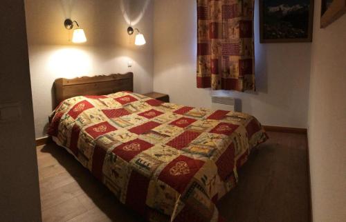 a bedroom with a bed with a quilt on it at Résidence Dryades Hameau De La Vallee D'or - 3 Pièces pour 6 Personnes 14 in Valloire