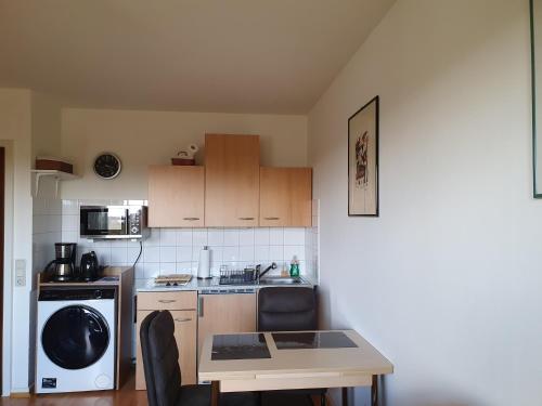 una pequeña cocina con mesa y fregadero en Single-Apartment Essen, en Essen