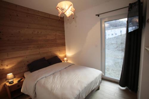 a bedroom with a bed and a large window at Les Chalets Du Grand Galibier - 3 Pièces pour 4 Personnes 44 in Valloire