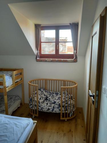 a bedroom with a crib and a window at Residence Spillenberg Apartment 1B in Levoča