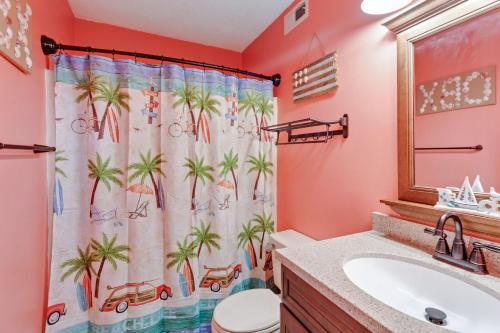 a bathroom with a shower curtain with palm trees at C223C Daze Aaah View Oceanfront Community Pool in Duck