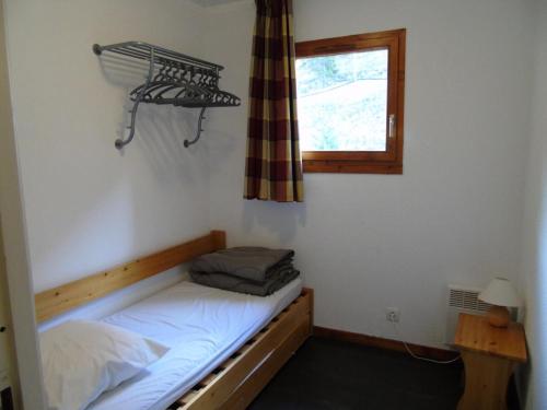 une petite pièce avec un lit et une fenêtre dans l'établissement Chalet Arrondaz - 3 Pièces pour 8 Personnes MAE-8734, à Modane