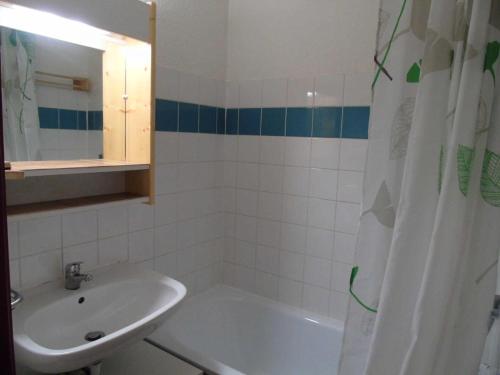 La salle de bains est pourvue d'un lavabo, d'une baignoire et d'un rideau de douche. dans l'établissement Résidence Cheval Blanc - 4 Pièces pour 8 Personnes MAE-8764, à Modane