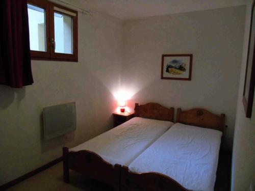 une chambre avec un lit et une lampe sur une table dans l'établissement Chalet Arrondaz - 2 Pièces pour 4 Personnes MAE-8794, à Modane