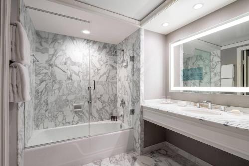 a bathroom with a tub and a sink at The Ritz-Carlton, St. Louis in Clayton