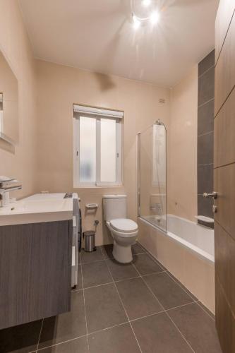 a bathroom with a toilet and a tub and a sink at The Pinnacle Fl6 city escape by Homely in Mellieħa
