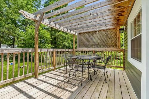 a patio with a table and chairs on a deck at The Peacock House - Close to Restaurants and Shops in Greensboro