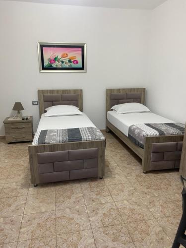 two twin beds in a room with at Vila Ajdinaj in Berat