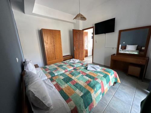 a bedroom with a bed and a dresser and a television at 4Seasons Sfakia in Khóra Sfakíon