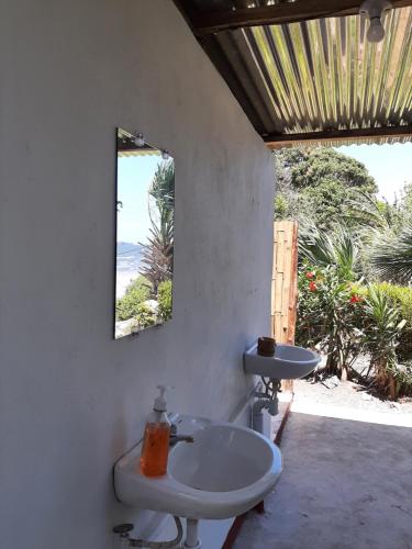 baño con lavabo y espejo en la pared en Playa Casa Nohelia, en Santo Domingo