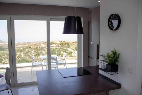 a kitchen with a table and a dining room with a view at Southridge PH with jacuzzi, TOP views by Homely in Mellieħa