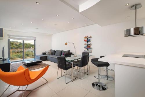 a kitchen and living room with a table and chairs at Mellieha Bay Designer Apartment By Homely in Mellieħa