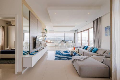 a living room with a couch and a tv at Luxury PH with rooftop pool in Mellieha by Homely in Mellieħa