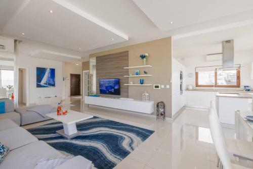 a living room with a couch and a table at Luxury PH with rooftop pool in Mellieha by Homely in Mellieħa