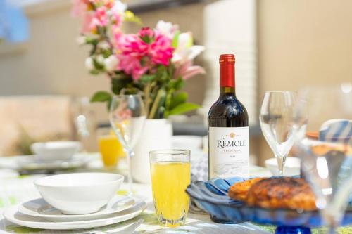 a bottle of wine sitting on a table with glasses at Villa Lorella - Private Pool, Jacuzzi By Homely in Mellieħa