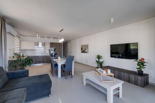 a living room with a couch and a table at Luxe 3br Melliehabay Stunning Terrace By Homely in Mellieħa