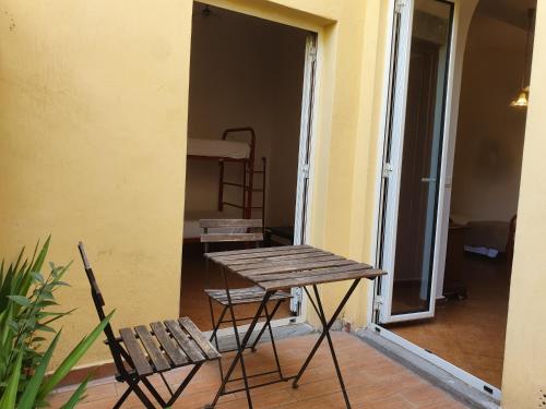 einen Tisch und eine Bank in einem Zimmer mit einem Bett in der Unterkunft New Hostel Florence in Florenz