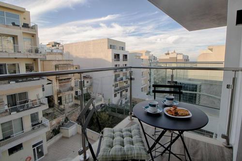 a balcony with a table with a plate of food on it at 3Bed Mellieha with shared heated pool by Homely in Mellieħa