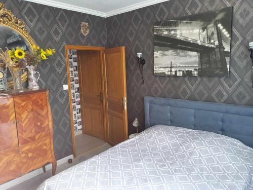 una camera con letto, cassettiera e specchio di Chez Yvonne a Oye-Plage