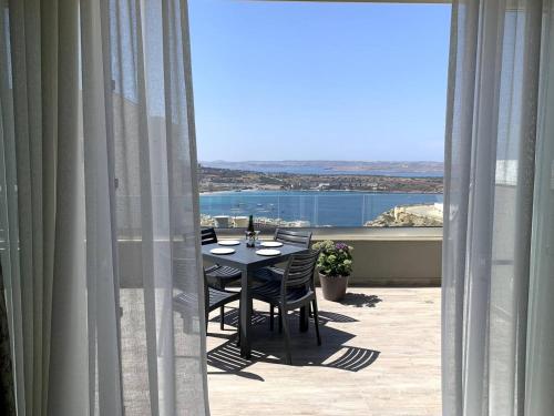 a table and chairs on a balcony with a view at Lovely Penthouse in Mellieha-seaview by Homely in Mellieħa