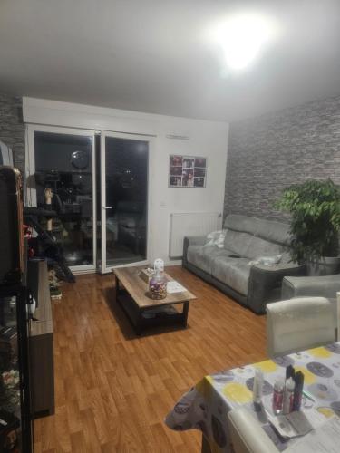 sala de estar con sofá y mesa de centro en Chambre 2 personnes atypique, en Vaires-sur-Marne