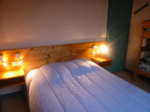 una camera da letto con un letto con due luci sopra di Résidence Les Glovettes - 2 Pièces pour 6 Personnes 624 a Villard-de-Lans