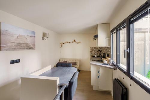 une cuisine avec des placards blancs et une grande fenêtre dans l'établissement Central & Stylish 1BD Duplex w GardenMontmartre!, à Paris