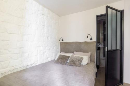 - une chambre avec un lit et un mur en briques blanches dans l'établissement Central & Stylish 1BD Duplex w GardenMontmartre!, à Paris