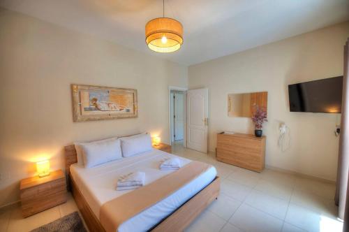 een slaapkamer met een groot bed en een flatscreen-tv bij Jonathan Cassar St Julians Lovely 3 Bedrooms in Taʼ Ċikkun